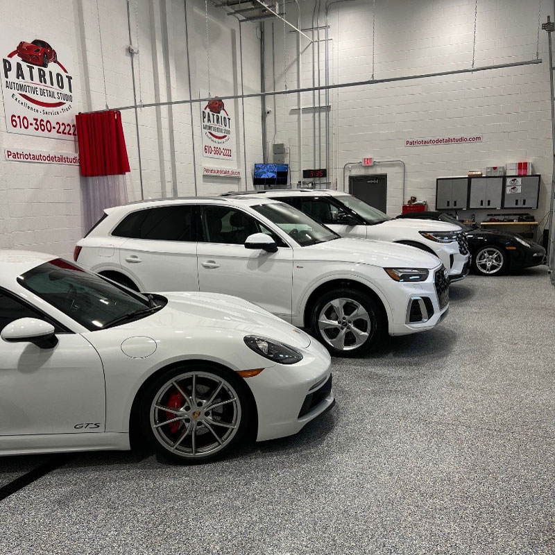 Four cars lined up inside the Patriot Automotive garage